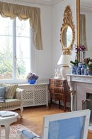 Miroir doré et meubles anciens dans un salon classique