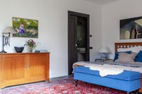 Chambre moderne avec pouf bleu au bout du lit