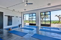 Studio de yoga avec portes ouvertes sur des vues panoramiques sur le paysage au-delà