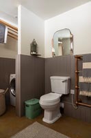 Toilettes et coin buanderie avec moustiquaire dans une salle de bains moderne