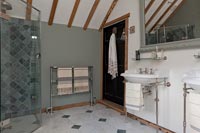 Salle de bain champêtre avec douche fermée et deux lavabos
