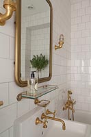 Robinets et accessoires en or dans la salle de bain blanche