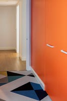 Portes d'armoire peintes en orange vif et tapis à motifs