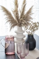 Détail d'herbes séchées dans des vases sur une table à manger moderne