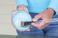 Femme utilisant un pinceau pour peindre la soucoupe
