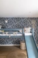 Chambre d'enfant avec papier peint et lit superposé avec toboggan