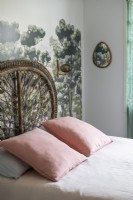 Peinture murale derrière le lit avec tête de lit décorative en osier