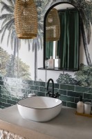 Lavabo dans la salle de bain moderne avec murale tropicale sur mur
