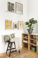 Salon contemporain minimaliste scandinave, meubles de couleur noir et chêne, étagères ouvertes et art mural