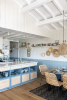 Cuisine-salle à manger bleue et blanche dans une cabane côtière