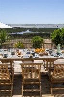 Table à manger extérieure dressée pour le déjeuner avec vue sur la côte en été