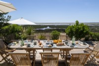 Table à manger extérieure prévue pour le déjeuner avec vue sur la côte en été