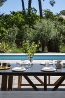 Table à manger extérieure posée pour le déjeuner sur la terrasse à côté de la piscine