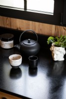 Théière et accessoires sur plan de travail de cuisine noir moderne