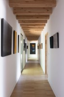 Vue le long d'un couloir moderne étroit avec des œuvres d'art sur les murs