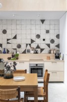 Cuisine-salle à manger moderne aux formes géométriques sur carrelage crédence
