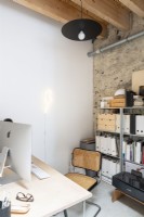Bureau à domicile moderne avec mur de plâtre nu et tuyauterie apparente