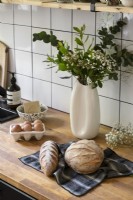 Composition florale et pain frais sur le plan de travail de la cuisine