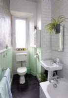 Salle de bain blanche avec boiseries peintes en vert menthe