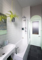 Salle de bain moderne blanche avec boiseries peintes vert menthe - porte