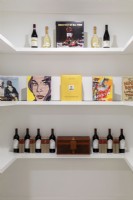 Étagères blanches avec affichage du vin et des livres
