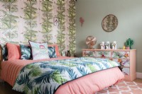 Chambre à coucher moderne avec papier peint et couvre-lit à motifs de palmiers et commode peinte à fleurs