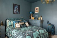 Chambre de couleur sarcelle avec linge de lit à motifs d'éléphants et meubles peints