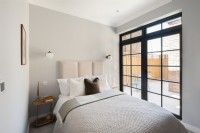 Chambre à coucher moderne avec portes menant à la terrasse-patio