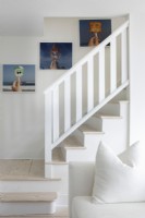 Escalier blanc avec des photographies sur le mur