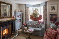Salon avec canapé confortable et cheminée, décoré pour Noël