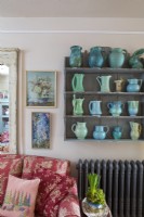 Étagère simple avec collection de vases bleus et verts, dans une maison de campagne confortable