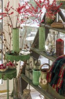 Vase et collection de pots avec des baies d'hiver et des décorations de Noël
