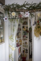 Feuillage et boules de Noël décoratifs suspendus devant le garde-manger de la cuisine