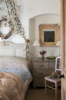 Chambre cottage décorée pour Noël, mobilier champêtre et guirlande de feuillage au dessus du lit