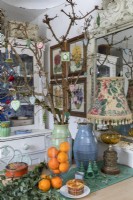 Table de cuisine avec des vases de branches d'arbres décorées au moment de Noël