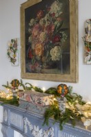 Cheminée décorée pour noël avec peinture de vase de fleurs ci-dessus