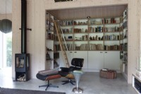 Coin bibliothèque, bibliothèques dans un salon décloisonné avec poêle à bois.