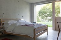 Chambre à coucher contemporaine avec sols et murs en béton