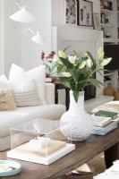 Vase blanc et fleurs sur table basse en bois
