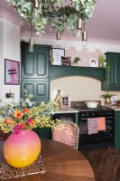 Cuisine avec gamme et armoires peintes en vert et plafond rose