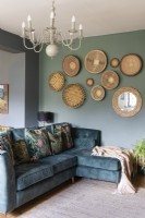 Canapé vert dans l'espace de vie avec affichage mural de style salon de paniers africains