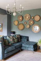 Canapé vert dans l'espace de vie avec affichage mural de style salon de paniers africains