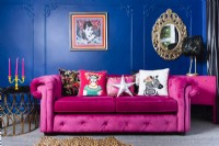 Canapé rose contre un mur bleu du salon