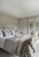 Grand lit en fer dans une chambre de style classique