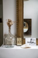 Détail d'objets de collection sur une étagère à côté d'un miroir doré