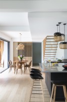 Cuisine-salle à manger moderne avec vue sur escalier flottant en bois