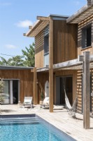 Maison en bois moderne avec piscine et coin salon en terrasse