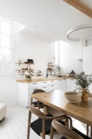 Cuisine-salle à manger peinte en blanc avec des meubles en bois