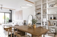 Espace de vie ouvert moderne peint en blanc avec table à manger en bois