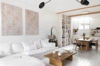 Espace de vie moderne décloisonné peint en blanc avec des meubles en bois